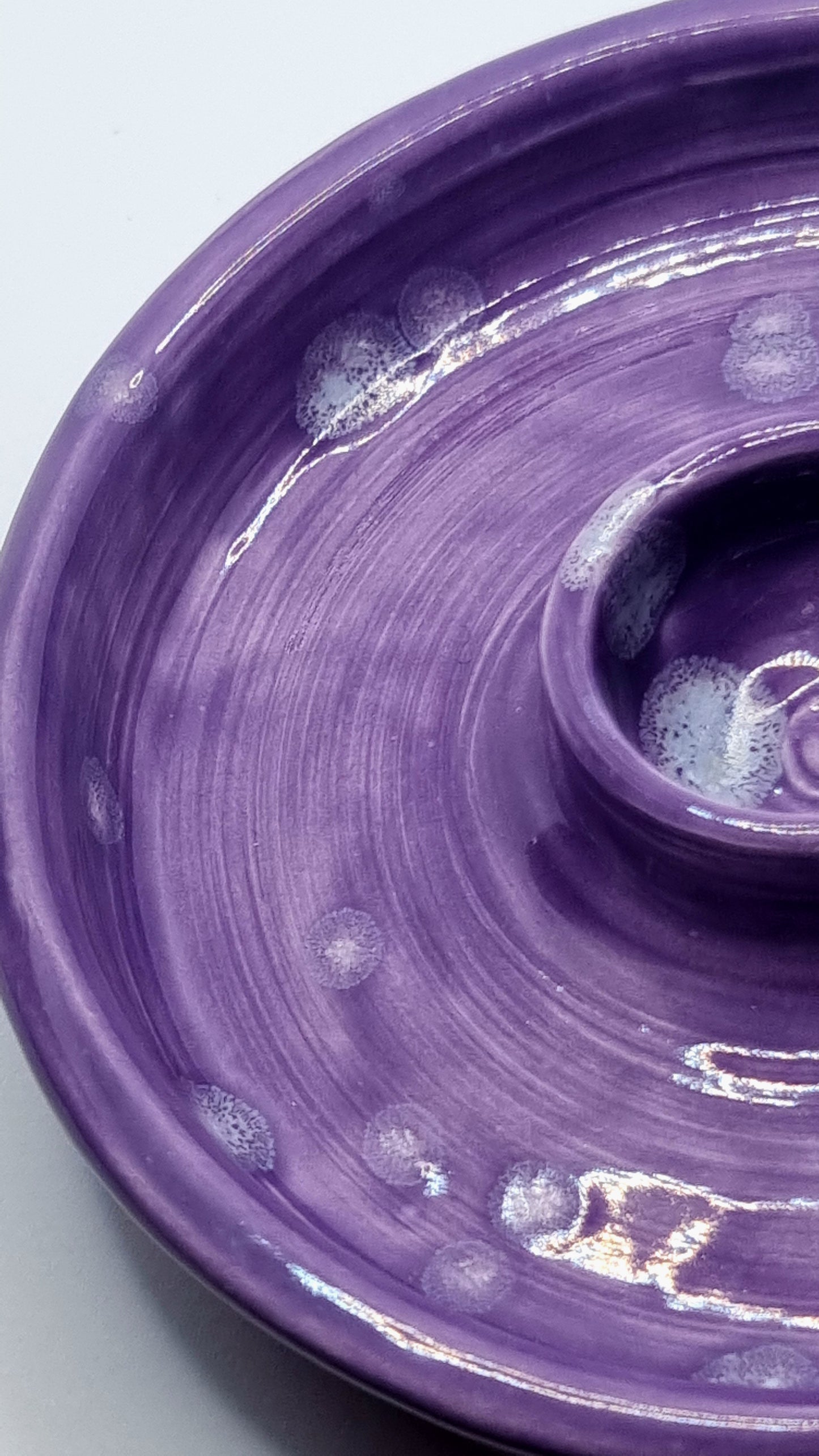 A purple candlestick on a neutral background