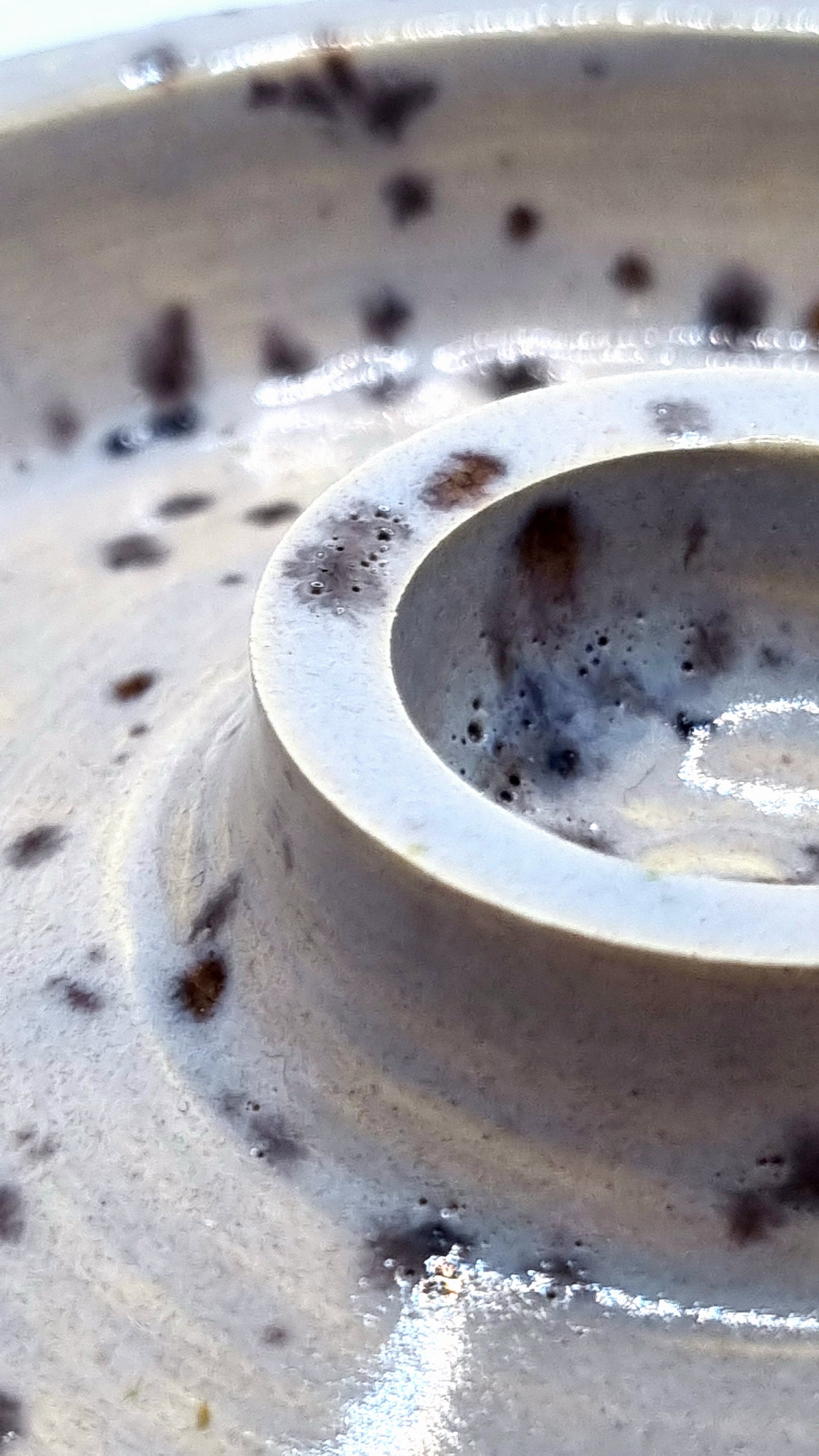 Close up of a candlestick in cream with lavender speckles on a neutral background