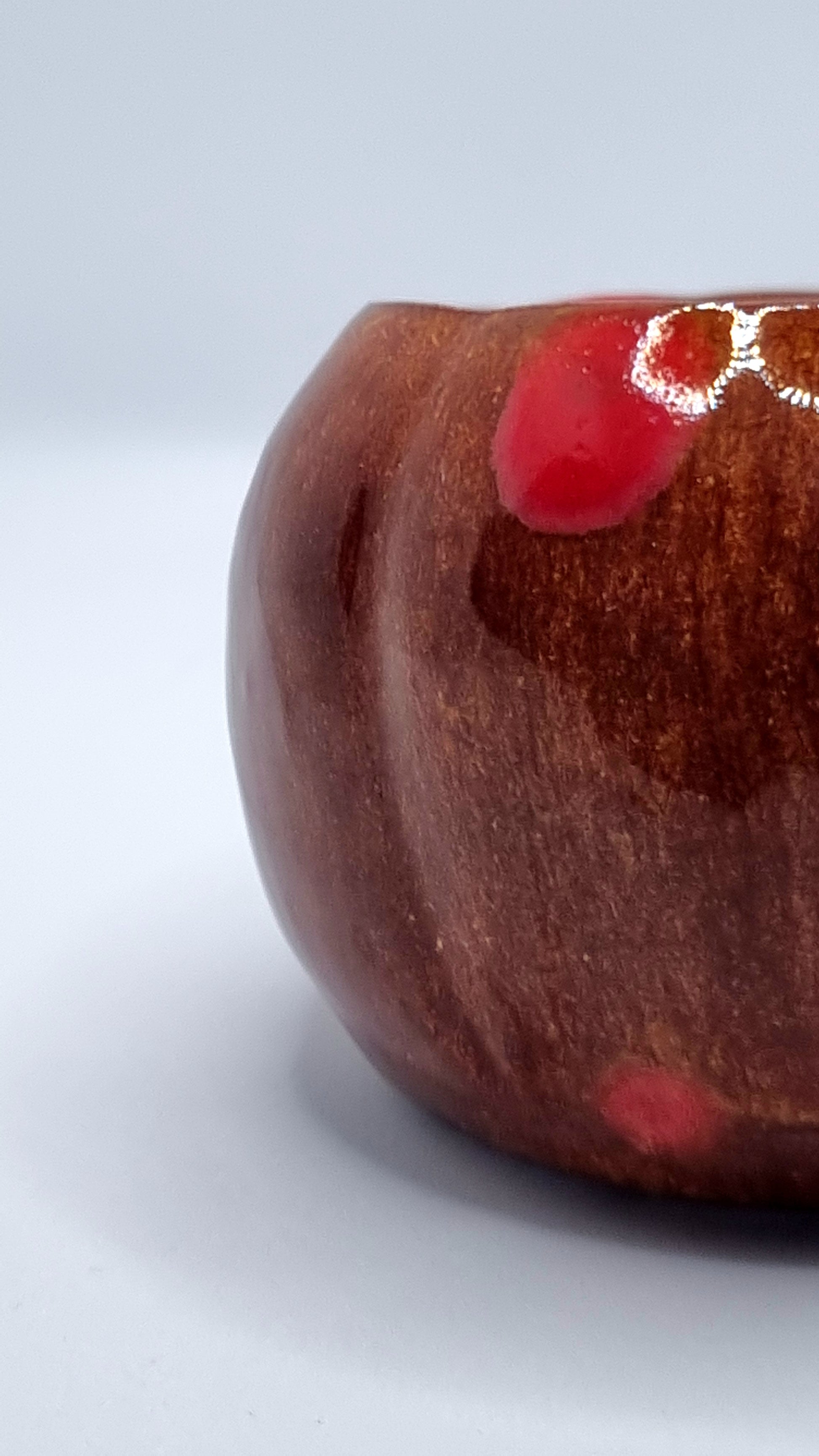 Close up of an orange pumpkin-shaped tealight holder on a neutral background 